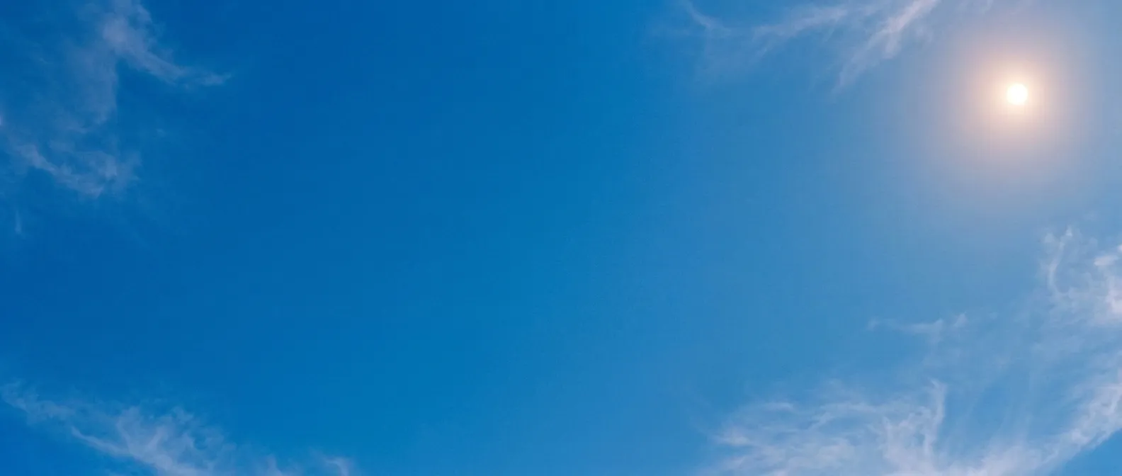 Blauer Himmel mit Sonne und feinen Schleierwolken